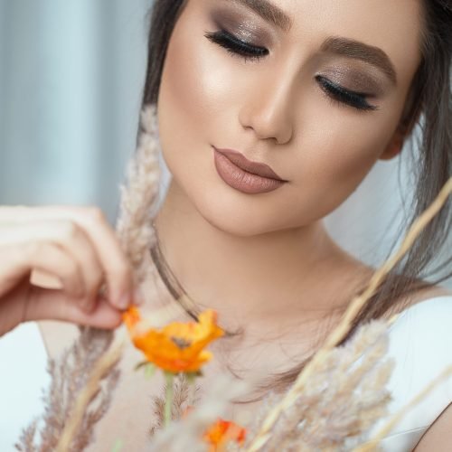 Model in light makeup holding spring flowers